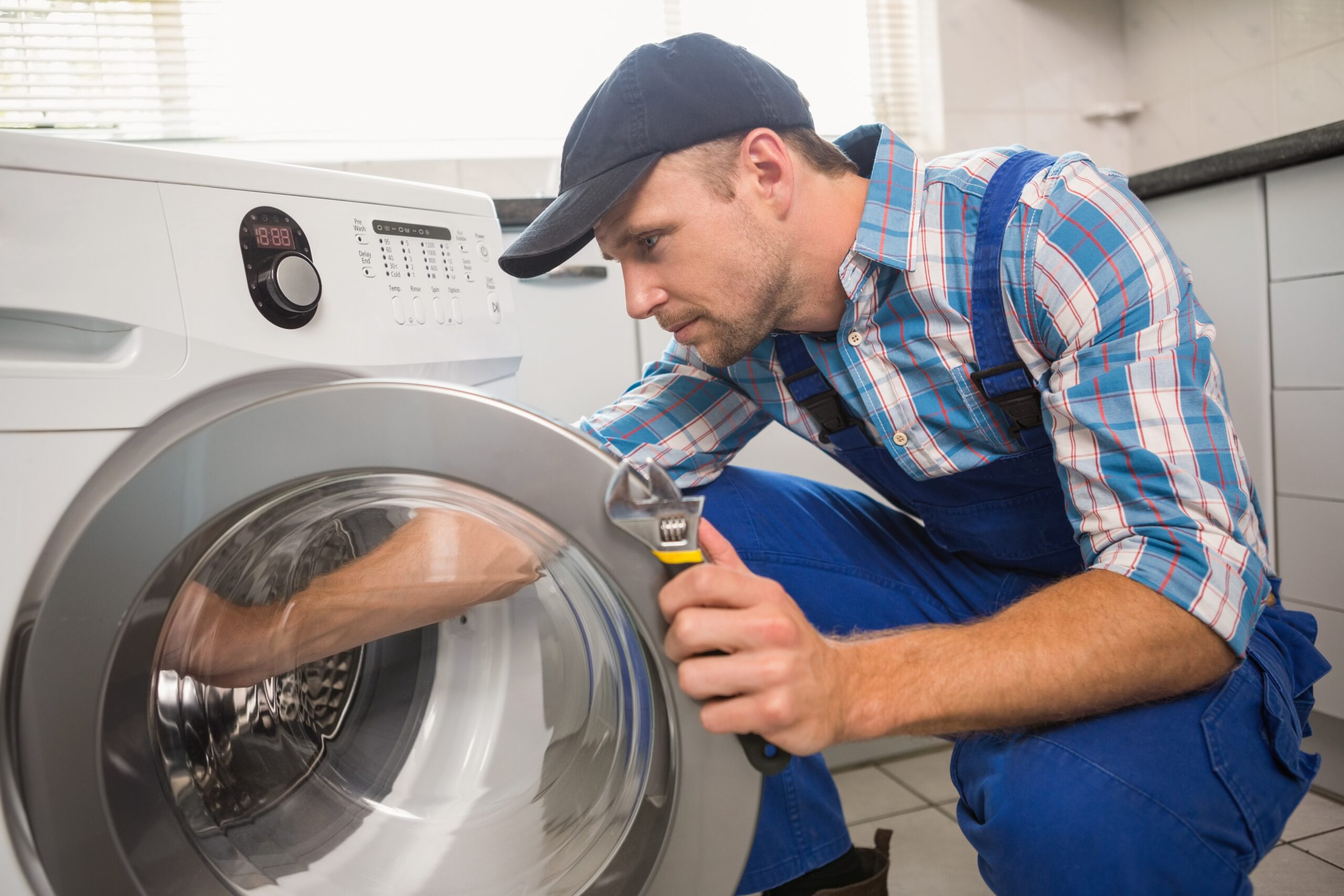 Ein Handwerker repariert eine Waschmaschine.