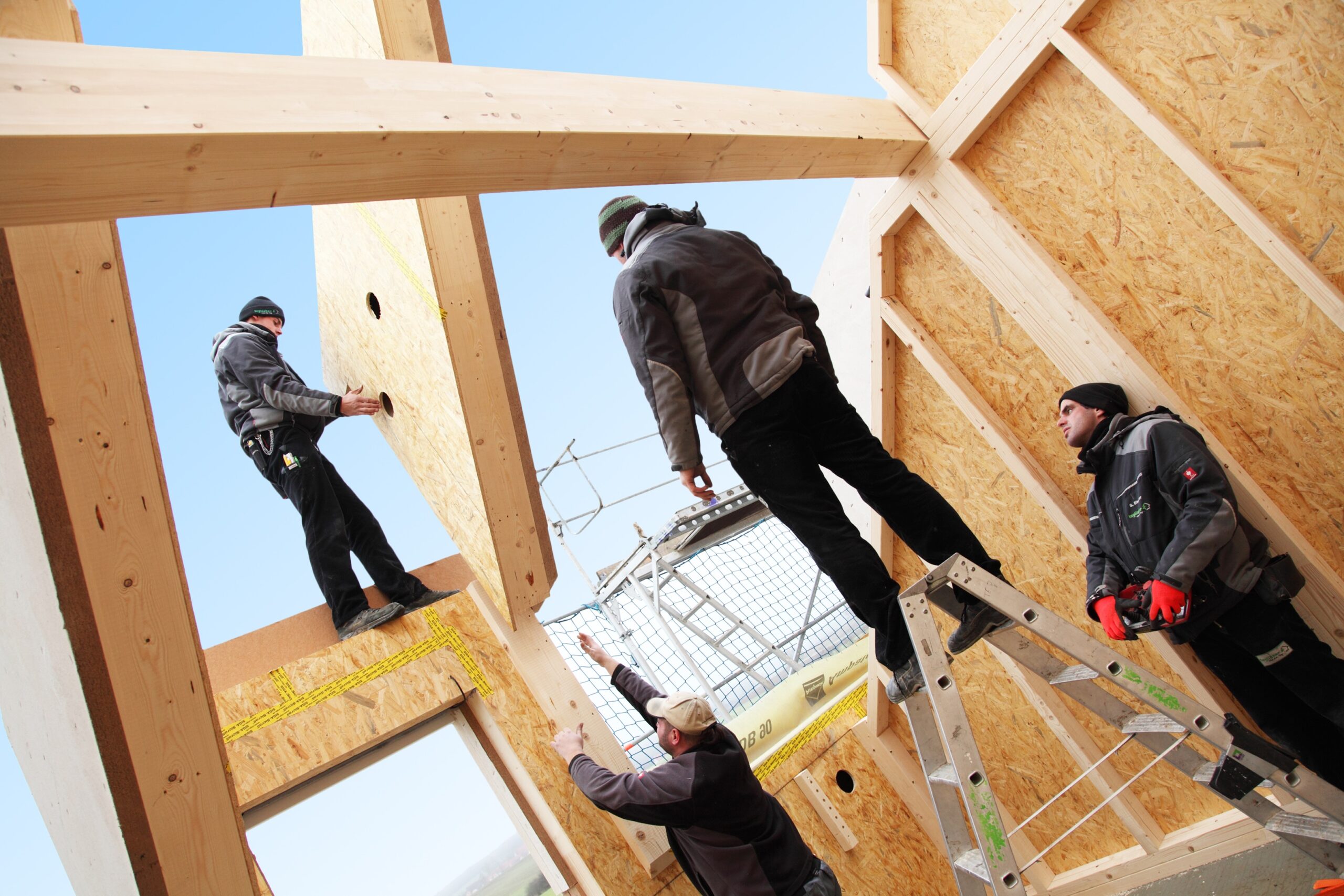 Bauarbeiter ziehen Teile des Dachs hoch.