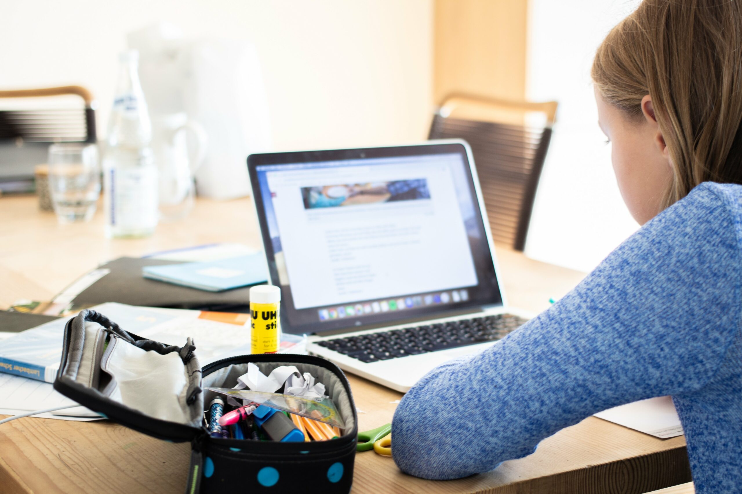 Eine Schülerin sitzt am Schreibstisch vor ihrem Laptop.
